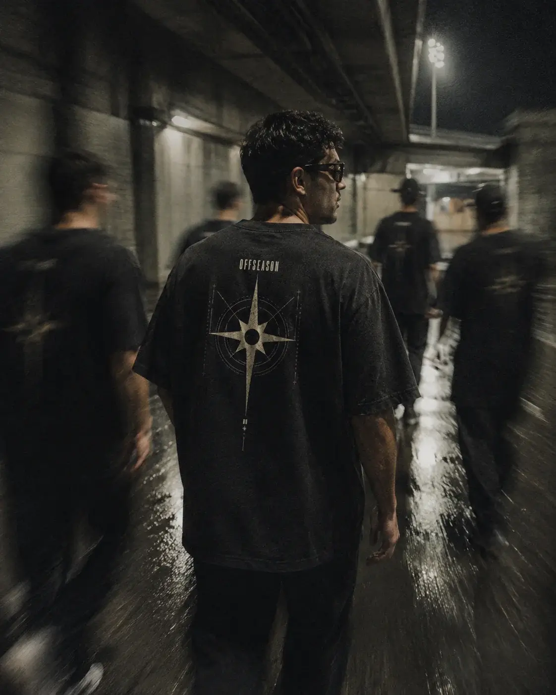 OFFSEASON tees worn through a floodlit stadium concourse